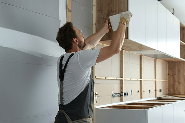 Menuisier agenceur en train de poser une cuisine
